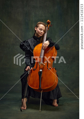 Tender beautiful woman, cellist in moment of calmness sitting with eyes closed, connecting deeply with the music. Symphony of feelings and sounds 111418153