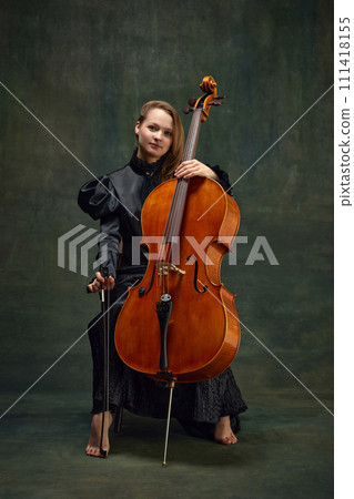 Female celloist sitting with cello on dark green background. Cover for upcoming music events, solo performance of classic melodies 111418155