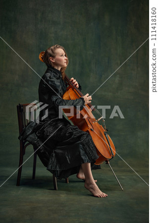 Elegant young woman, talented, passionate cellist looking upward, reflecting creativity and inspiration while playing. Catching inspiration 111418160