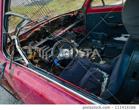 An old burnt-out red car in close-up. The concept of danger and disaster. 111418166