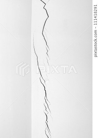 Deep crack in the white wall in close-up. Plaster cracked. Problems of construction and repair. Deep crack in the white wall in close-up. Plaster cracked. Problems of construction and repair. 111418291
