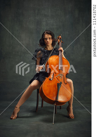 Female celloist sitting with cello on dark green background. Book cover for musician's memoir, emphasizing personal and artistic growth. 111418702