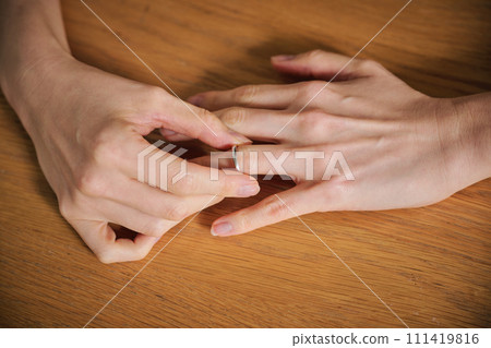 女人的手摘下結婚戒指 女人的手摘下結婚戒指 111419816