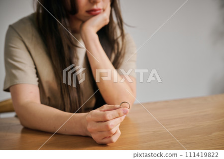 一名30多歲的女士摘下結婚戒指 一名30多歲的女士摘下結婚戒指 111419822