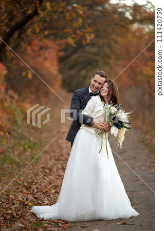 beautiful sensual bride in white wedding dress and groom standing on natural background 111420759