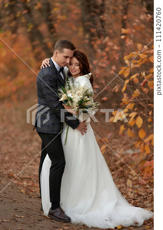 beautiful sensual bride in white wedding dress and groom standing outdoor on natural background 111420760