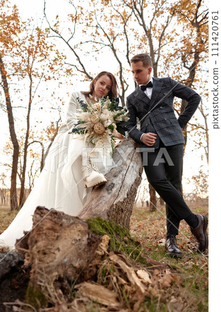 beautiful sensual bride in white wedding dress and groom standing outdoor on natural background 111420761