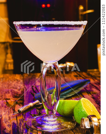 Margarita cocktail with lime in a glass on wooden table. Shallow dof Margarita cocktail with lime in a glass on wooden table. Shallow dof 111422083