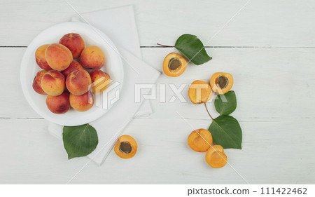 Ripe apricots on the table. wooden background. apricots and green leaves. Flat lay. Top view.  111422462