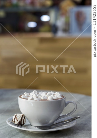Composition of mug of coffee with marshmallows on porcelain plate on light background, top view. Composition of mug of coffee with marshmallows on porcelain plate on light background, top view. 111422555