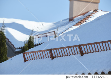 Snow guard for safety in winter on house roof top covered with steel shingles. Tiled covering of building Snow guard for safety in winter on house roof top covered with steel shingles. Tiled covering of building 111422699