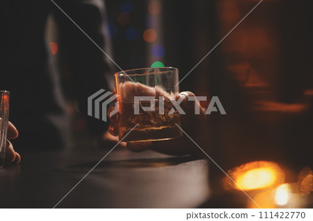 Celebration night, pour whiskey into a glass. Give to friends who come to celebrate 111422770
