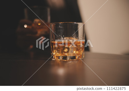 Celebration night, pour whiskey into a glass. Give to friends who come to celebrate 111422875