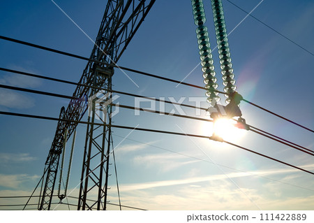 High voltage tower with electric power lines divided by safe guard bushing transfening safely electrical energy through cable wires. Electricity transmission on long distance concept High voltage tower with electric power lines divided by safe guard bushing transfening safely electrical energy through cable wires. Electricity transmission on long distance concept 111422889