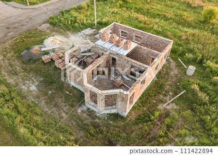 Aerial view of building site for future house, brick basement floor and stacks of brick for construction. 111422894