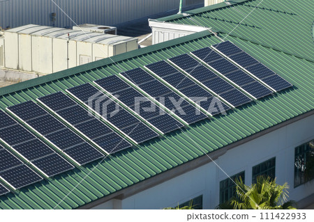 Aerial view of american condo building roof with blue solar photovoltaic panels for producing clean ecological electric energy. Renewable electricity with zero emission concept Aerial view of american condo building roof with blue solar photovoltaic panels for producing clean ecological electric energy. Renewable electricity with zero emission concept 111422933