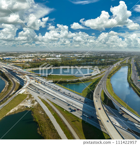 USA transportation infrastructure concept. View from above of american big freeway intersection in Miami, Florida with fast moving cars and trucks USA transportation infrastructure concept. View from above of american big freeway intersection in Miami, Florida with fast moving cars and trucks 111422957