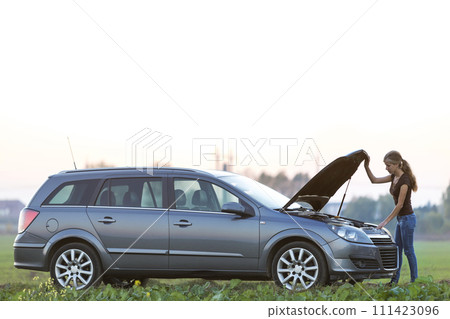 Young woman and a car with popped hood. Transportation, vehicles problems and breakdowns concept. 111423096
