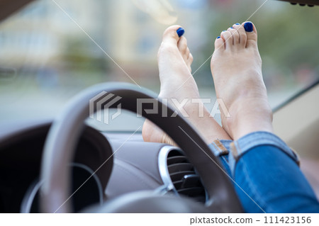 Close up of woman driver feet resting on car dashboard. Close up of woman driver feet resting on car dashboard. 111423156