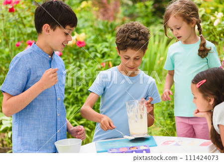 Group of children making homemade ice-cream at cooking masterclass Group of children making homemade ice-cream at cooking masterclass 111424073