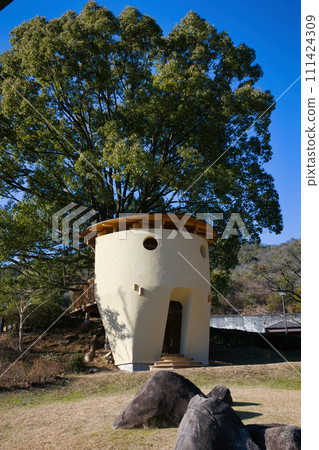 Large trees and distinctive wooden deck playground equipment in the park 111424309
