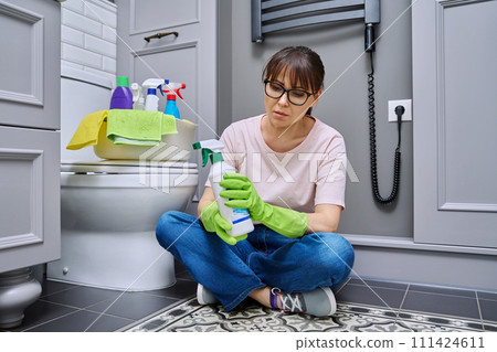Woman reading label on spray cleaner, composition, instructions for use Woman reading label on spray cleaner, composition, instructions for use 111424611