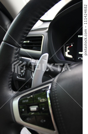 Gear shifter and headlight control lever under steering wheel of modern car 111424682