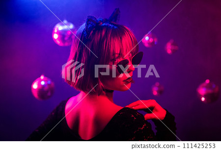 Portrait of young pretty woman neon light. Pussy cat costume for halloween party Portrait of young pretty woman neon light. Pussy cat costume for halloween party 111425253