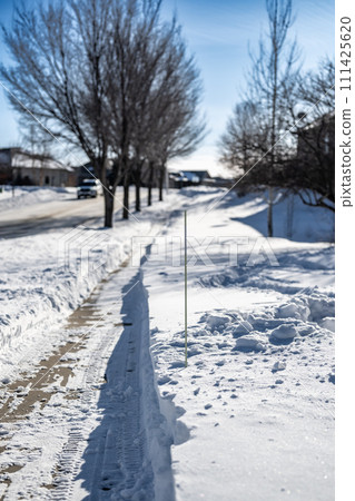 Sidewalk with edge markers used for snow blowing guides 111425620