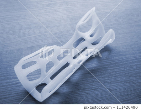 Hand arm splint corset prosthesis langet printed on a 3D printer from molten plastic. Medical orthosis, fixator, plastic overlay created on 3D printer. New modern medical 3D printing technologies 111426490