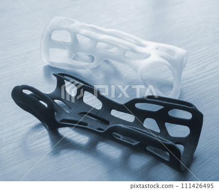 Hand arm splint corset prosthesis langet printed on a 3D printer from molten plastic. Medical orthosis, fixator, plastic overlay created on 3D printer. New modern medical 3D printing technologies Hand arm splint corset prosthesis langet printed on a 3D printer from molten plastic. Medical orthosis, fixator, plastic overlay created on 3D printer. New modern medical 3D printing technologies 111426495