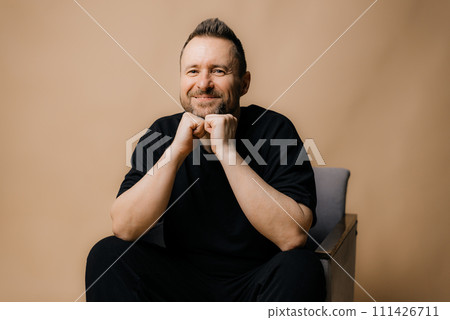 Portrait of smiling mature man standing on beige background. 111426711