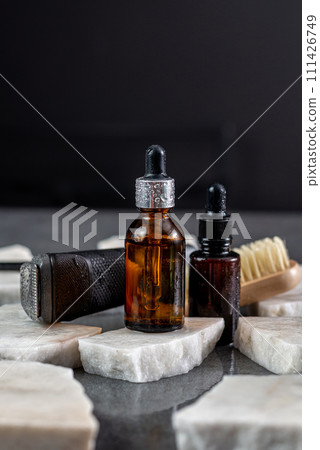 Man beard grooming items on a stone table surface, comb, oil and electric trimmer 111426749