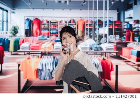 Young woman shopping at a clothing store 111427001