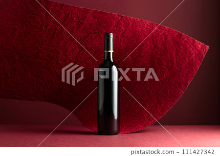 Bottle of red wine on a red background. 111427342