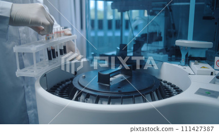 Scientist puts blood samples from tube rack into medical device Scientist puts blood samples from tube rack into medical device 111427387