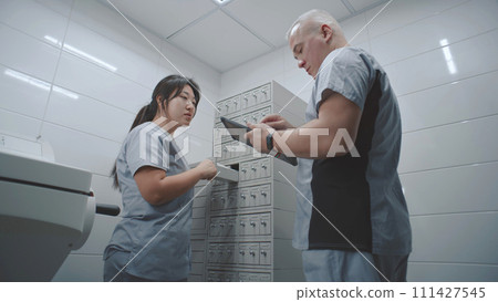 Diverse scientists check samples of tests using digital tablet 111427545
