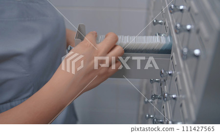 Microbiologist takes sample with blood test from medical storage cabinet 111427565