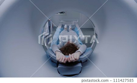 Caucasian woman undergoes MRI or CT scan procedure in hospital Caucasian woman undergoes MRI or CT scan procedure in hospital 111427585