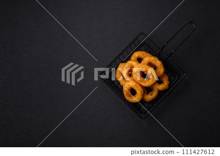 Delicious nutritious squid or onion rings deep fried with salt and spices 111427612