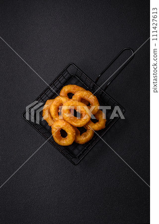 Delicious nutritious squid or onion rings deep fried with salt and spices Delicious nutritious squid or onion rings deep fried with salt and spices 111427613