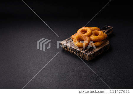 Delicious nutritious squid or onion rings deep fried with salt and spices Delicious nutritious squid or onion rings deep fried with salt and spices 111427631