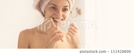 Woman brushes her teeth near the mirror. Woman brushes her teeth near the mirror. 111428600
