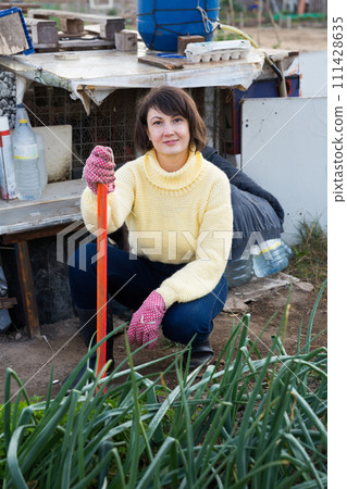 Woman working in garden Woman working in garden 111428635