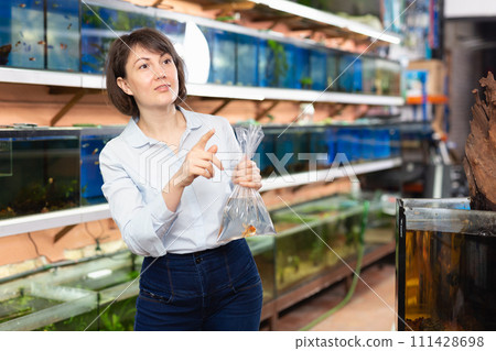 Woman holding plastic bag with fish 111428698