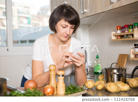Woman reading news on her smartphone Woman reading news on her smartphone 111428708