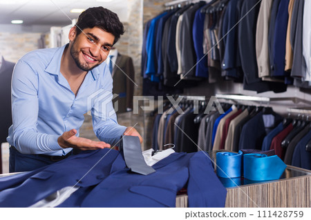 Male is showing jacket and tie that he chose 111428759