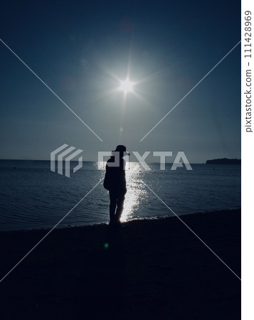 A woman standing on the beach 111428969