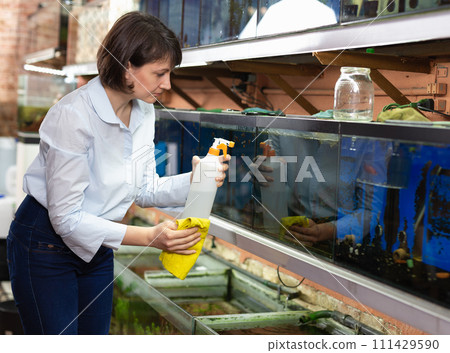 Saleswoman cleaning fish tanks Saleswoman cleaning fish tanks 111429590