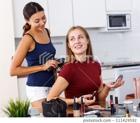 Female friends applying cosmetics 111429592